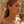 Load image into Gallery viewer, Woman wearing gold earrings with green and blue gemstones against a blurred natural background
