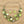 Load image into Gallery viewer, A green beaded jewelry set featuring a multi-strand statement necklace and matching drop earrings with square and cylindrical beads in various shades of green, including lime, forest, and gradient styles, accented with silver-toned beads on a white background.
