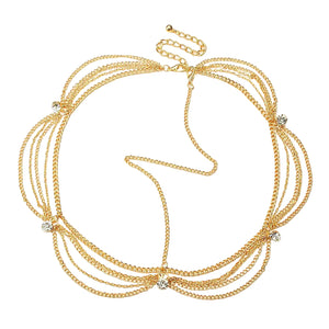 Gold necklace with multiple strands on a light gray background