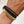 Load image into Gallery viewer, Close-up of a wrist wearing black and gold hair ties on a plain background
