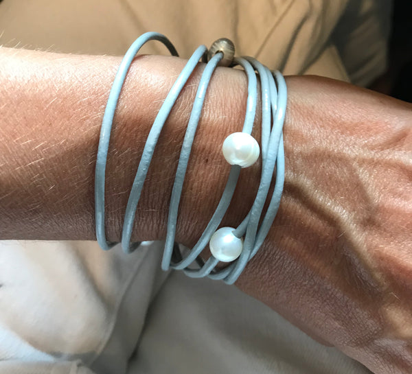 Light blue bracelet with pearl beads on a wrist