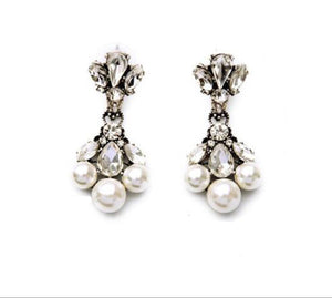 Pair of pearl and crystal earrings on a white background