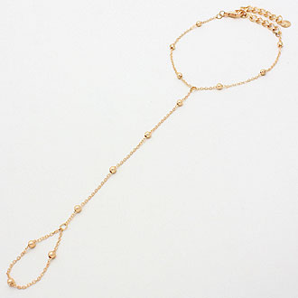 Gold necklace with small beads on a light gray background