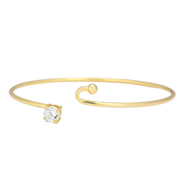 Gold bracelet with a diamond on a light gray background