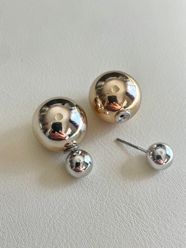 Pair of silver spherical earrings on a light gray background