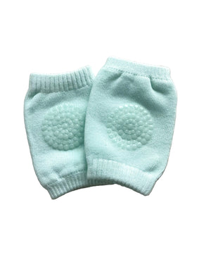 Pair of light blue baby knee pads on a beige surface