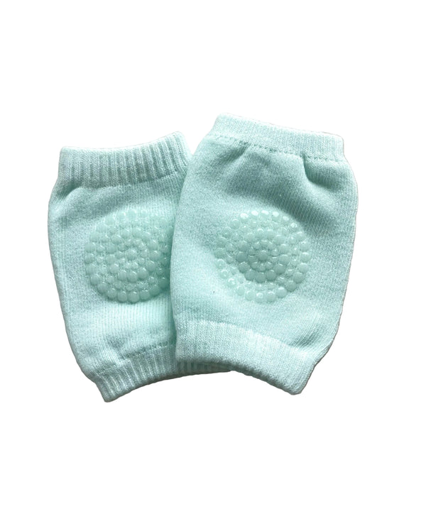 Pair of light blue baby knee pads on a beige surface