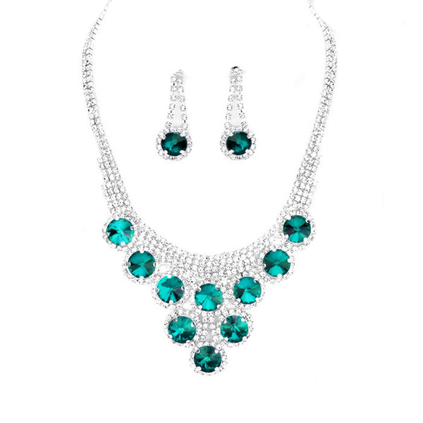 Jewelry set with emerald green gemstones on a white background
