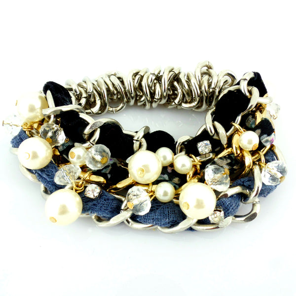 Multistrand bracelet with pearls, crystals, and fabric on a white background