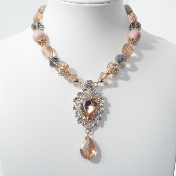 Necklace with pink and gold beads on a mannequin