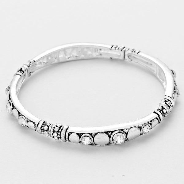 Silver bracelet with embedded stones on a light gray background