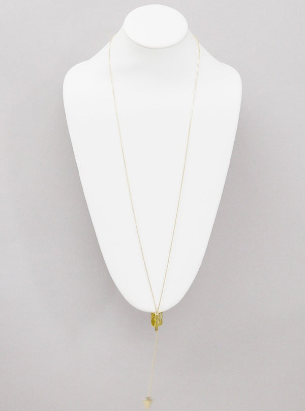 Necklace on a mannequin bust against a gray background