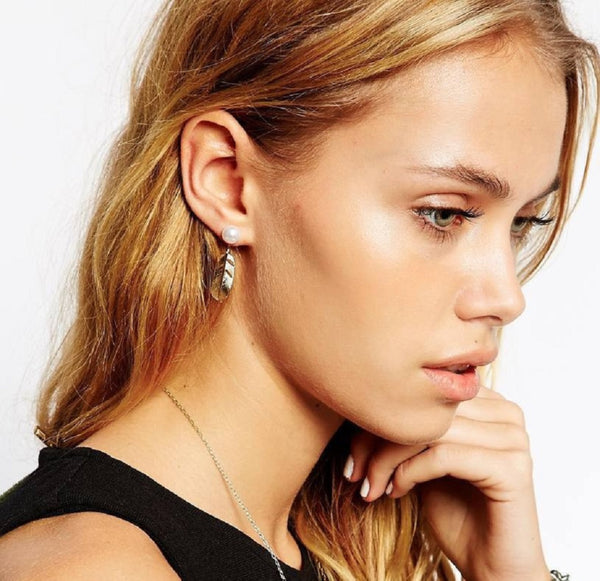 Close-up of a woman wearing earrings with a plain background