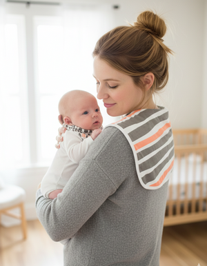 Woman holding a baby in a room with a crib in the background