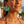 Charger l'image dans la galerie, Woman wearing turquoise tassel earrings with a blurred beach background
