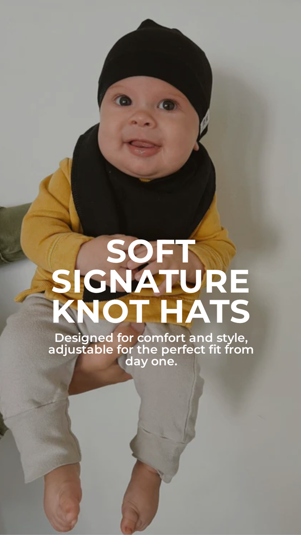 Baby wearing a black knot hat with text about soft signature knot hats.