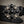 Charger l'image dans la galerie, A close-up of a black leather belt featuring an ornate silver-tone buckle adorned with faceted black and smoky-tinted crystals on a textured gray background.
