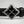 Load image into Gallery viewer, A close-up of a black leather belt featuring a large diamond-shaped silver buckle with four black inlay panels.
