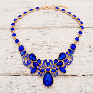Necklace with blue stones and gold accents on a wooden surface