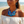 Charger l'image dans la galerie, A woman on a beach wearing a chunky blue disc necklace with silver beaded accents and matching blue drop earrings, paired with a white off-the-shoulder top.
