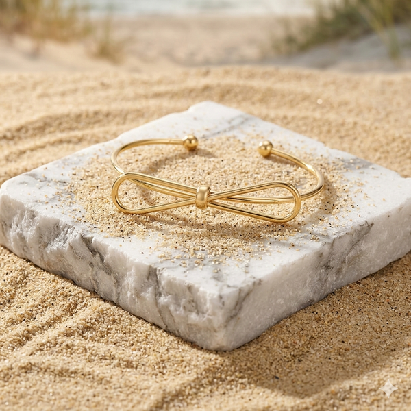 Gold bracelet on a marble stone with sand in the background