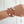 Load image into Gallery viewer, Wrist wearing multiple brown bracelets with white beads on a light wooden background
