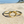 Charger l'image dans la galerie, Gold bracelet with interlocking rings on a sandy beach
