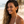 Load image into Gallery viewer, Woman with wavy hair and a white top standing on a beach.
