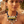 Charger l'image dans la galerie, A woman wearing a chunky statement necklace with blue braided cord, white and yellow geometric beads, and clear faceted crystal drops, photographed outdoors with a warm blurred background.
