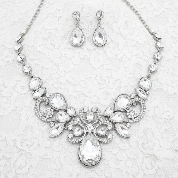 Jewelry set with necklace and earrings featuring teardrop-shaped crystals on a white background