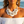 Charger l'image dans la galerie, A woman at the beach wearing a chunky statement necklace made of large white disc shells and silver-toned beads, along with matching dangling earrings.
