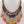 Charger l'image dans la galerie, Necklace and earrings set with red, blue, and gold beads on a mannequin.
