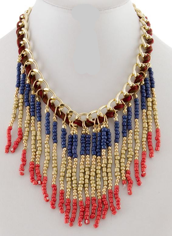Necklace and earrings set with red, blue, and gold beads on a mannequin.