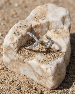 Silver ring with diamond details on a textured stone surface