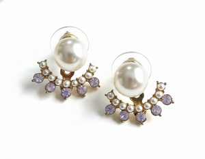 Pair of pearl earrings with purple accents on a white background
