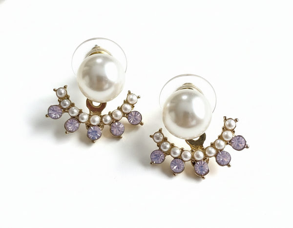 Pair of pearl earrings with purple accents on a white background