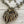 Load image into Gallery viewer, An antique bronze and gold-toned necklace with a large, organic leaf-shaped pendant featuring cutout branches, accompanied by matching dangling leaf earrings, displayed on a light wood background.
