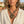 Load image into Gallery viewer, A woman wearing a bohemian-style bronze necklace with a large textured heart pendant and matching leaf earrings, styled with a white linen shirt in an outdoor setting.
