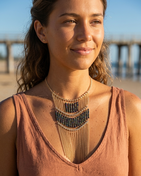 Woman wearing a layered necklace on a beach