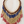 Charger l'image dans la galerie, Beaded necklace with red, blue, and gold beads on a light wooden surface
