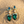 Charger l'image dans la galerie, Green teardrop earrings with pearl and gemstone details on a sandy background
