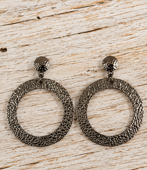 Hammered gunmetal circle earrings on pale barn wood