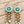 Load image into Gallery viewer, Handmade mint aqua crochet flower earrings with acrylic beads and gold tone chain tassels on pale barn wood
