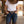 Load image into Gallery viewer, A person wearing a white t-shirt, blue jeans, a brown leather belt with a large silver heart-shaped buckle, and cowboy boots, standing in a rustic wooden western-style corridor.
