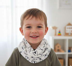 Child wearing a white scarf with black patterns in a room with toys on shelves.