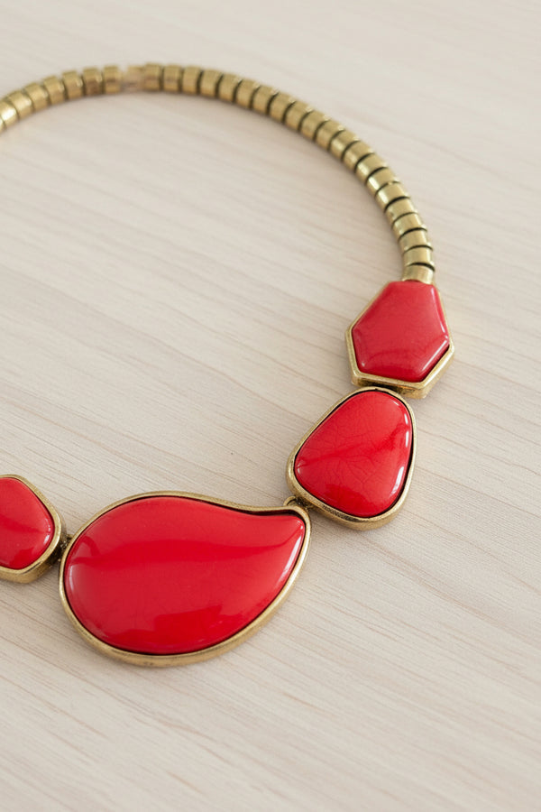 Necklace with red teardrop-shaped pendants on a dark surface