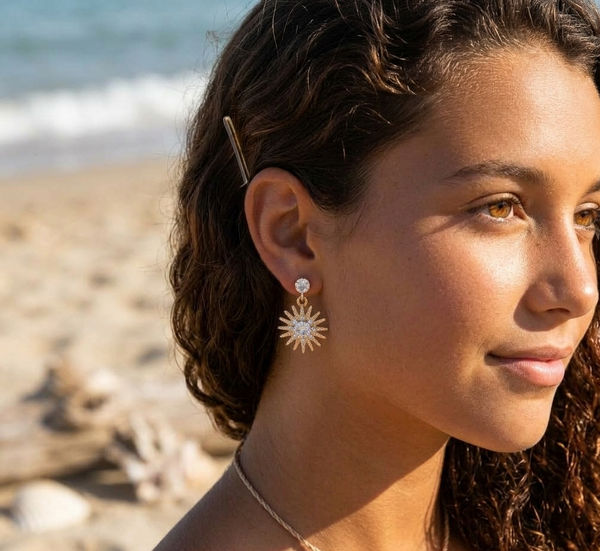 Woman wearing sun-shaped earrings on a beach