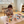 Load image into Gallery viewer, Child painting on a table with art supplies in a room with large windows.
