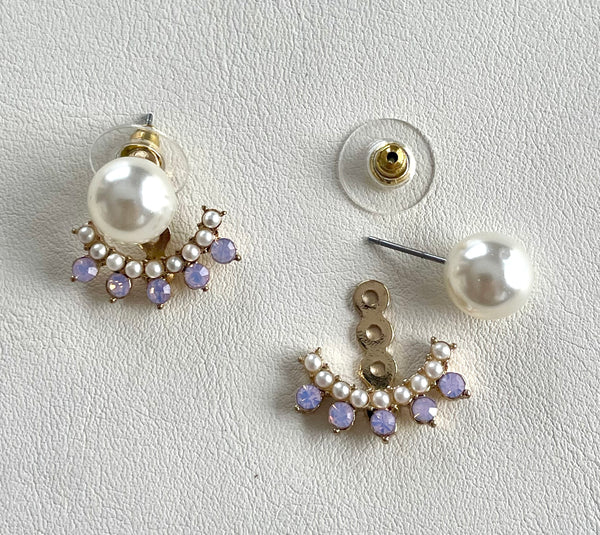 Pair of pearl earrings with gold accents on a light gray background