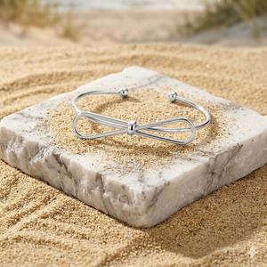 Silver bracelet on a stone with sand in the background